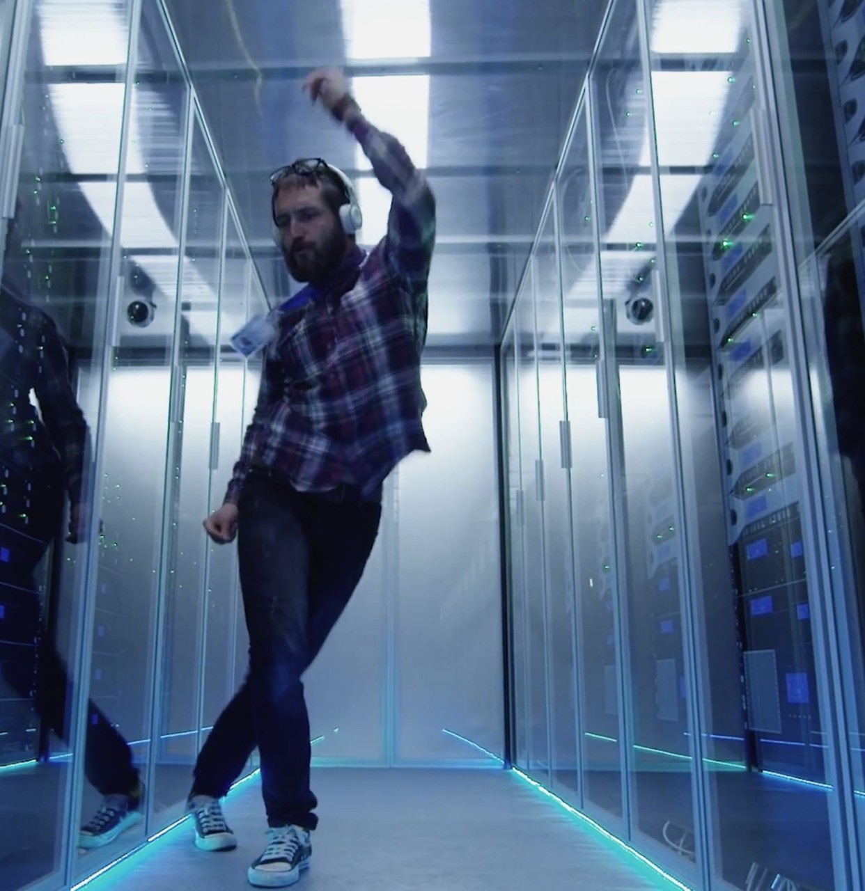 Man with headphones dancing in data center