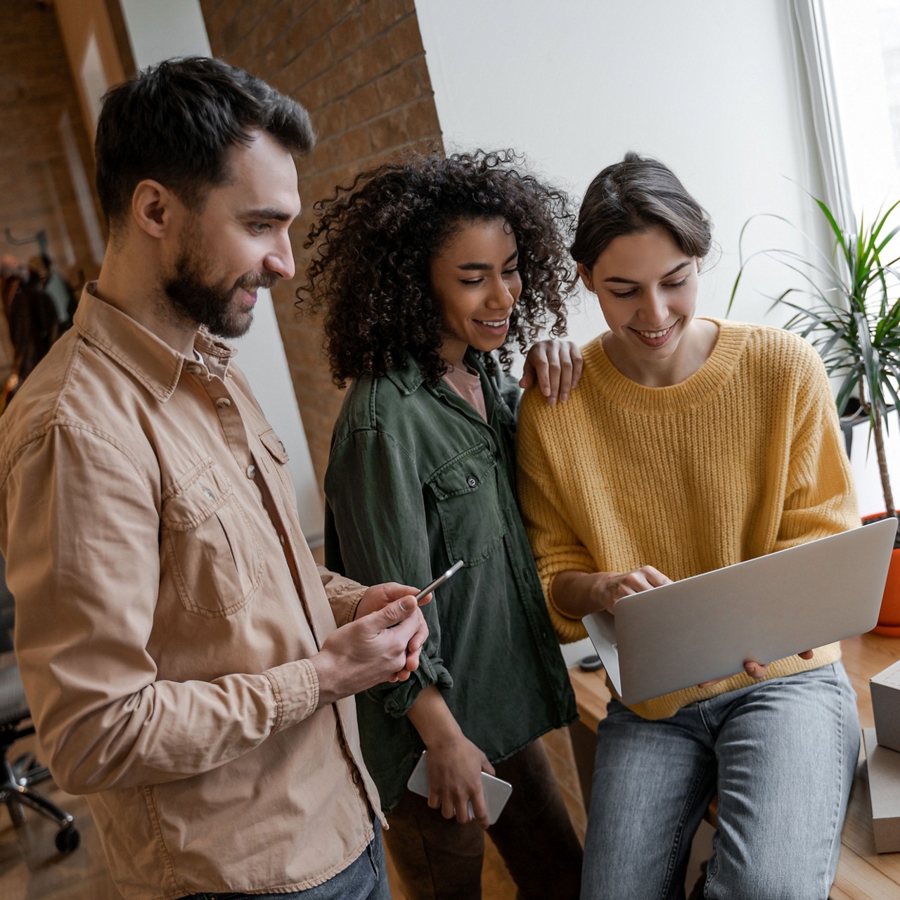 Group of people standing and looking at a laptop screen